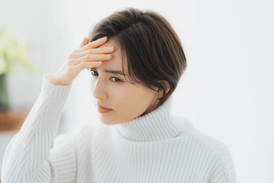 女性が額に手を当てて困ったような表情