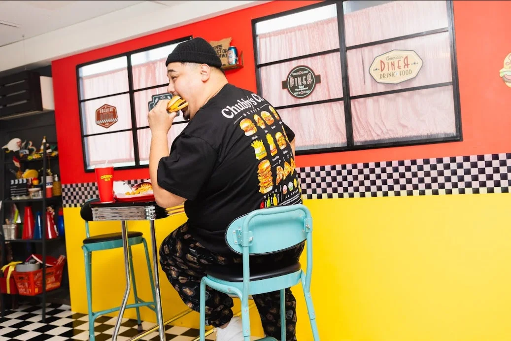 ダイナーでハンバーガーを食べる男性